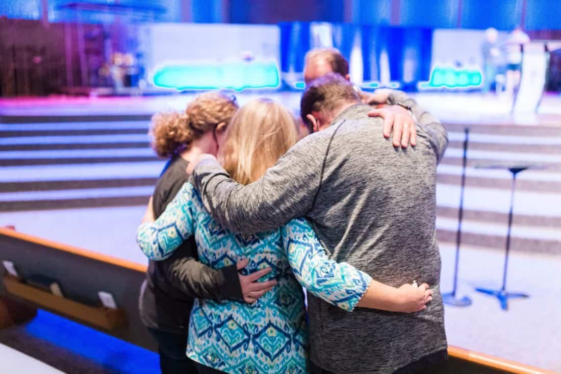 Four people praying together at church.
